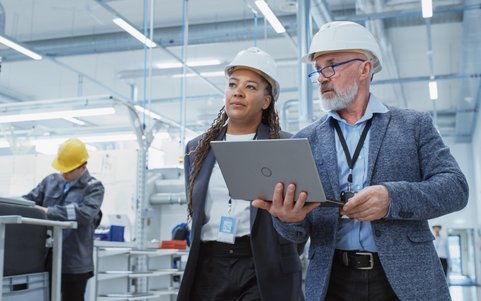 Two occupational safety professionals holding a laptop.