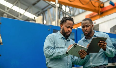 Two occupational safety professionals holding a tablet.