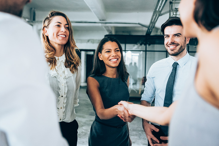 A group of business professionals meeting and shaking hands.